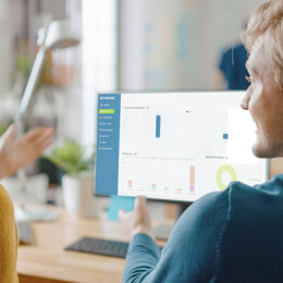 Two Employees looking at the RCS Thrift Production Enhancement data on a computer screen.