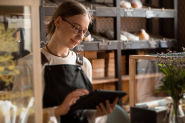 Employee on a mobile tablet in a specialty market.