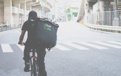 Uber Eats delivery bike rider on a bike riding down the street.