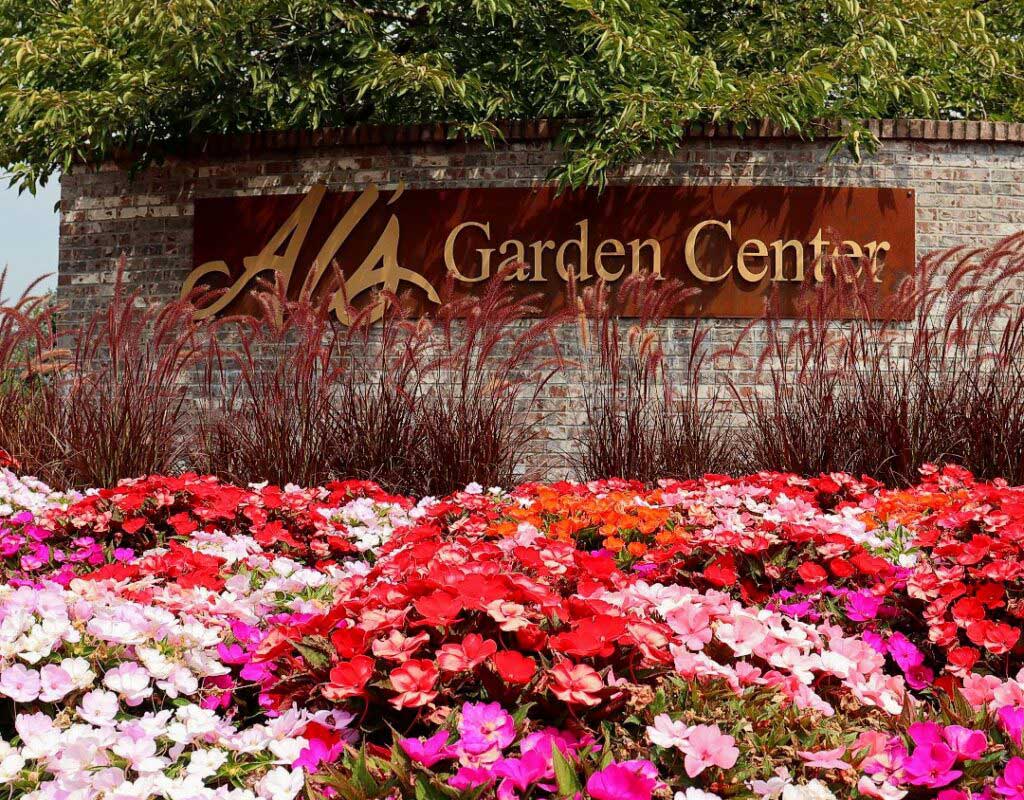 Al's Garden Center sign out in front of their store, with flowers in the foreground.