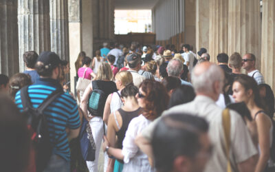 Long line of patrons waiting in line to get into a busy museum/attraction.