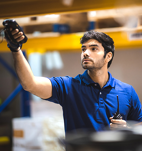 Warehouse worker using mobile barcode scanner to analyze newly arrived inventory for further placement in storage department, logistic working at warehouse.