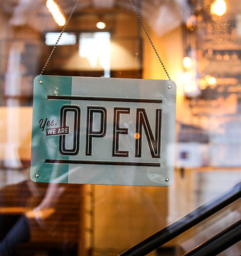 Yes, we are open sign on the front of a multi-location retail store.