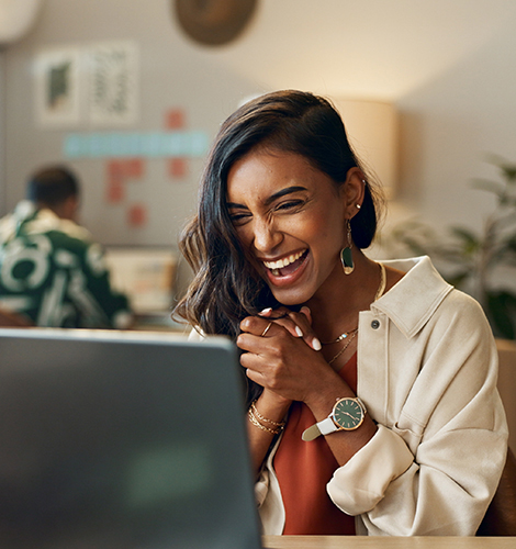 Excited woman looking at a desktop computer. She is excited about all the integrations her point of sale system is now capable of.