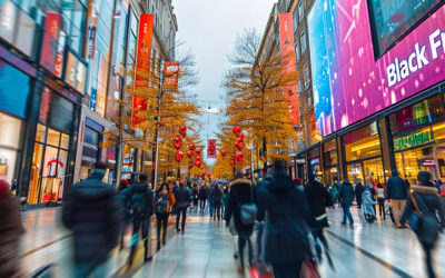 Shoppers in a busy shopping area during the holiday season. A Black Friday sign is above one of the shops.