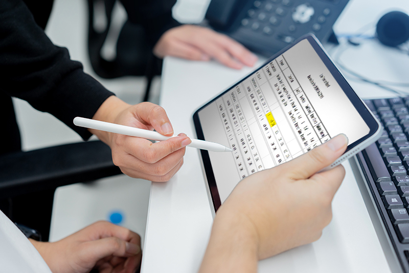 Two employees looking at KPI metrics on a tablet.