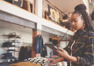 Woman performing a year-end inventory count of all the retail merchandise using mobile technology.