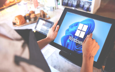 An employee looking at a point of sale monitor with a Windows 11 background on the display in a retail store.