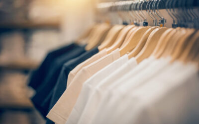 T-shirts on hangers hanging on a rack. The shirts are organized and ready to be counted for a year-end inventory count.